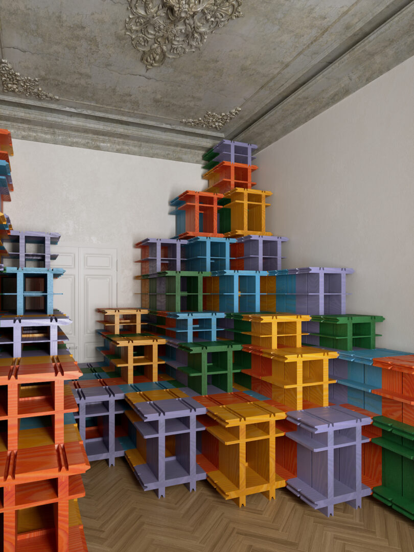 Room with high ceiling containing multiple colorful stacked crates arranged against the walls and corner, creating a vibrant, organized display. The wooden floor and ornate ceiling details are visible