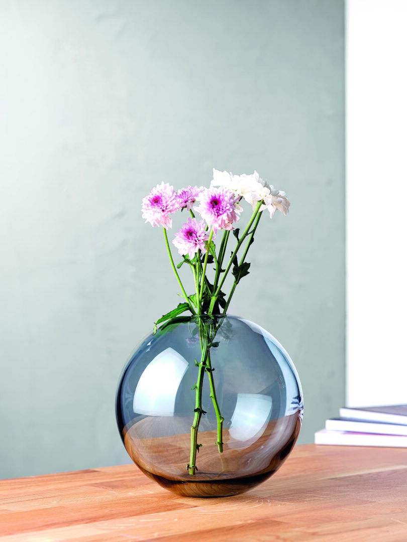 round blue glass vase with flowers