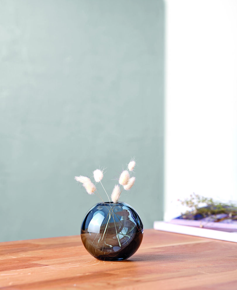 round blue glass vase with flowers