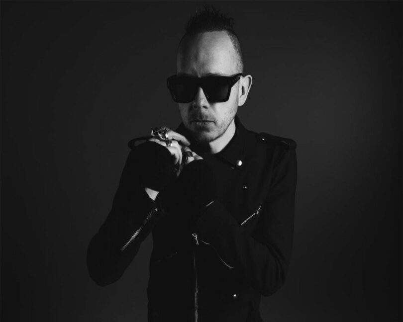 A black and white, moody photo of a man in sunglasses