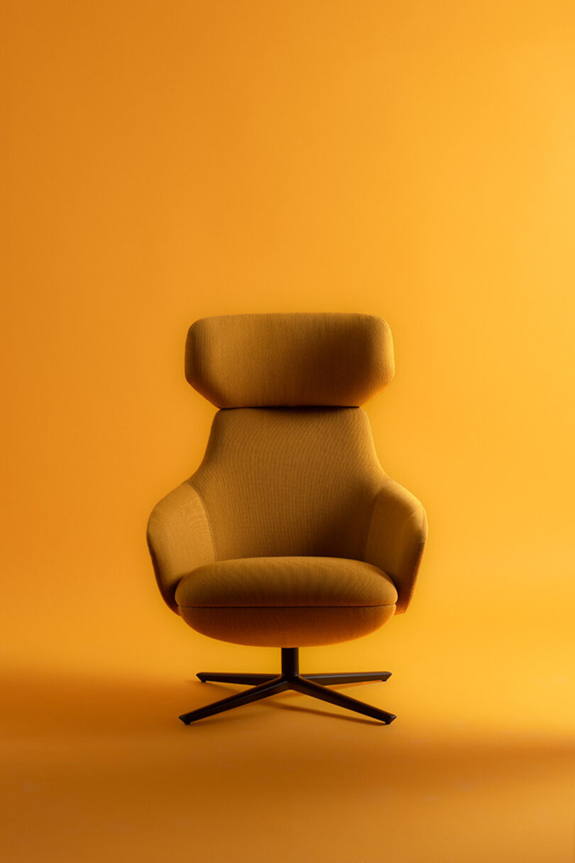 Modern yellow armchair with a high backrest on a black swivel base against a matching yellow background