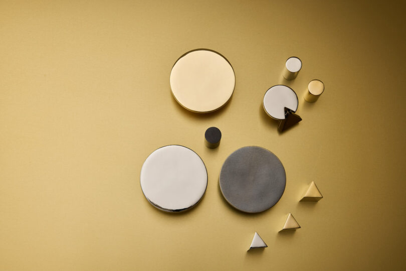 A collection of gold, silver, and black geometric hardware on a gold background
