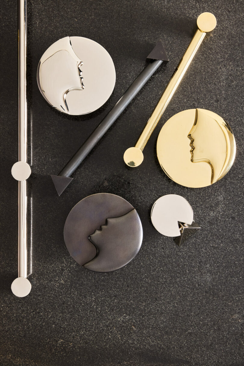 A collection of gold, silver, and black geometric hardware on a charcoal background