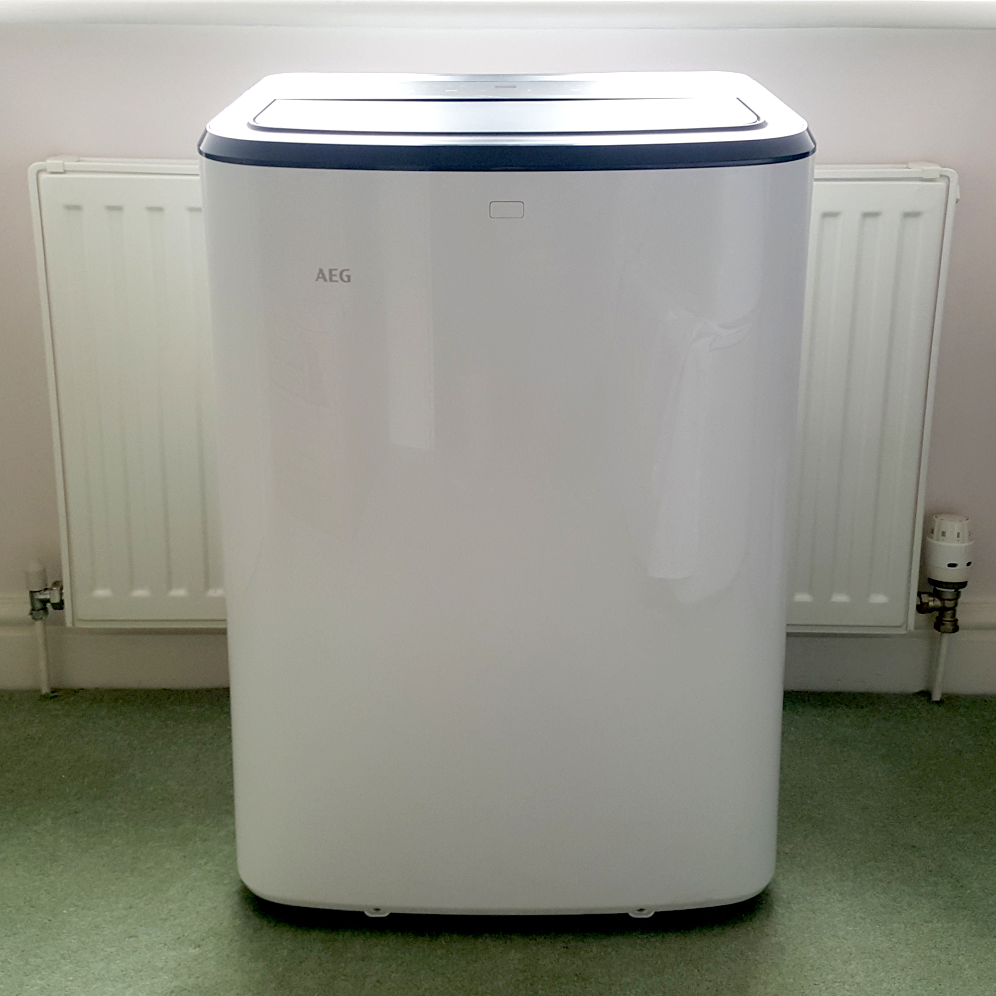 The AEG Comfort 6000 Portable Air Conditioner being tested in a room with green carpet