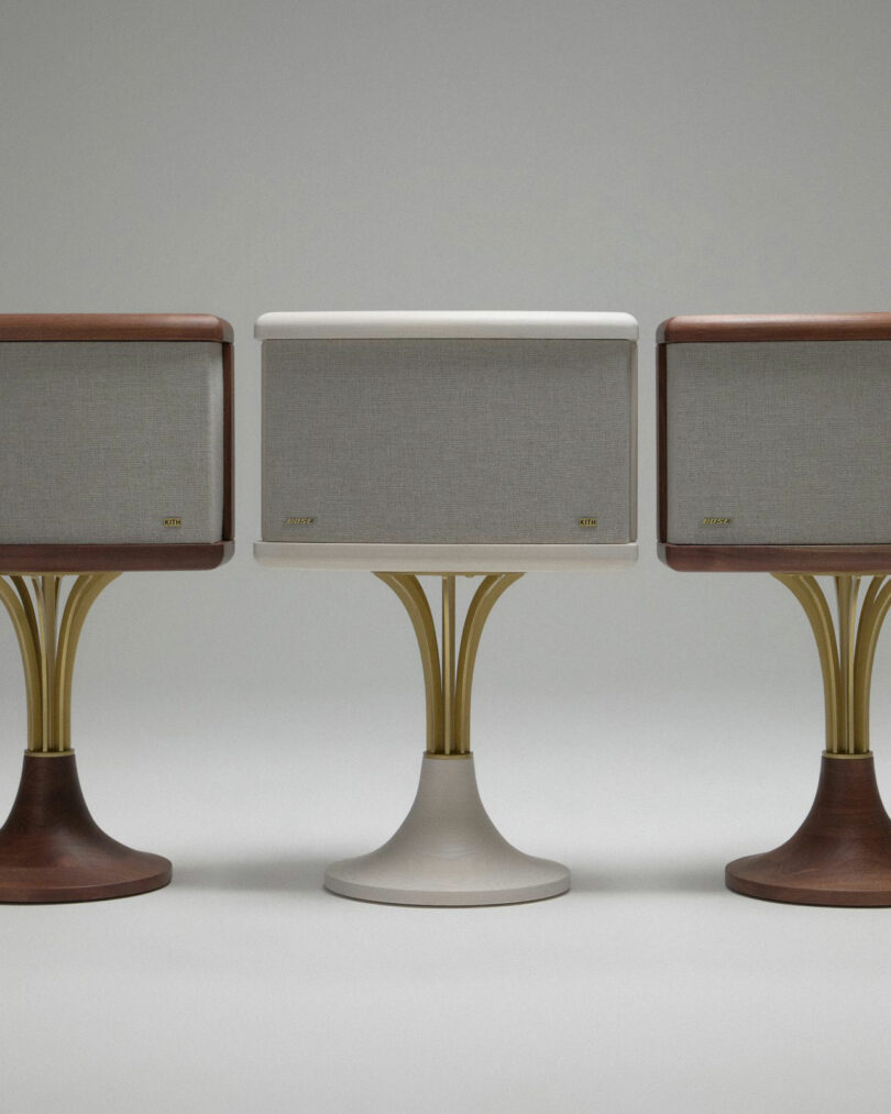 Three retro-style speakers by Mark Jupiter with pedestal bases—two in wood finishes and one in white—are arranged side by side against a plain background.
