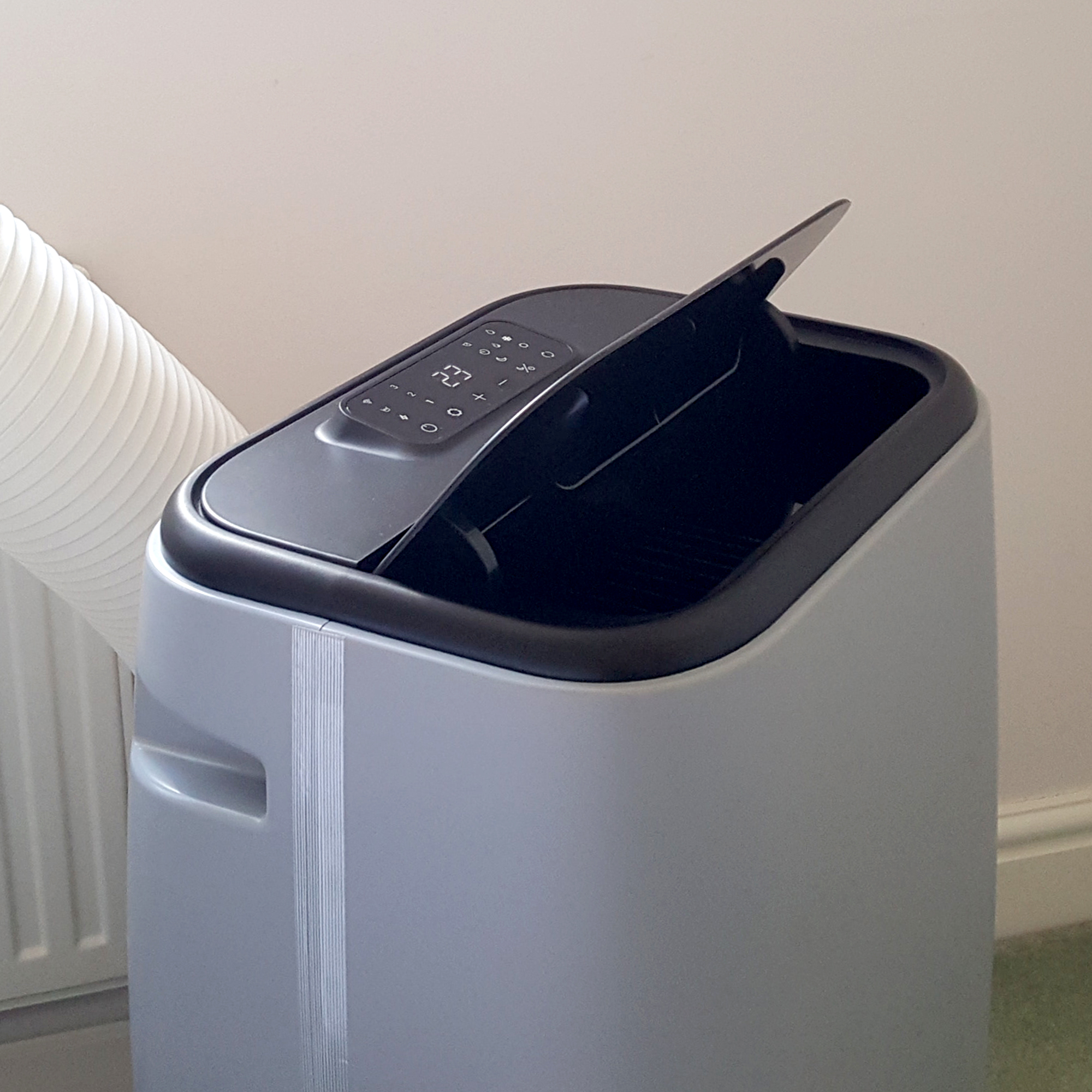 The Duux North 9K Smart Air Conditioner being tested in a room with a green carpet