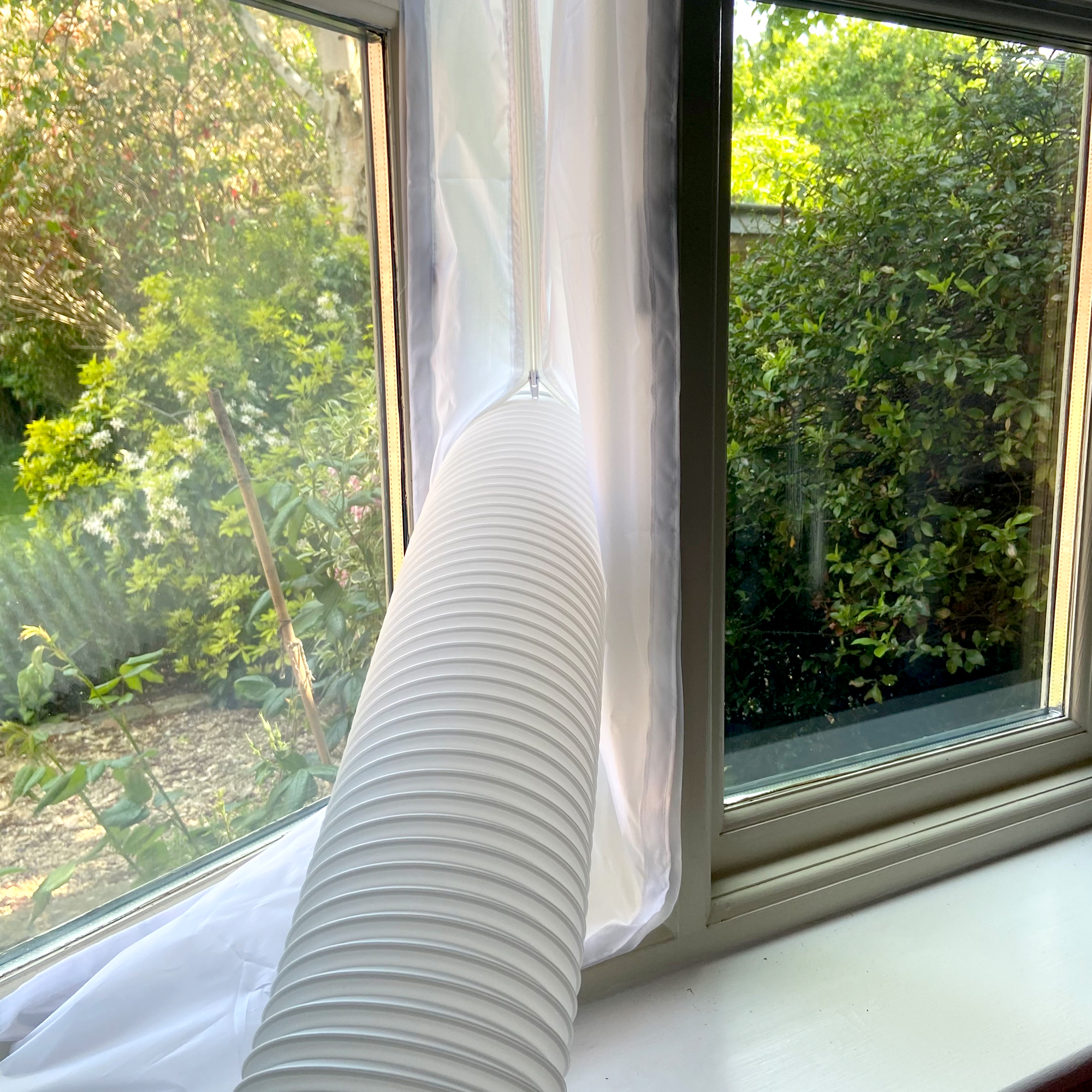 The MeacoCool MC Series 7000BTU Portable Air Conditioner  being vented out of a window via the exhaust hose