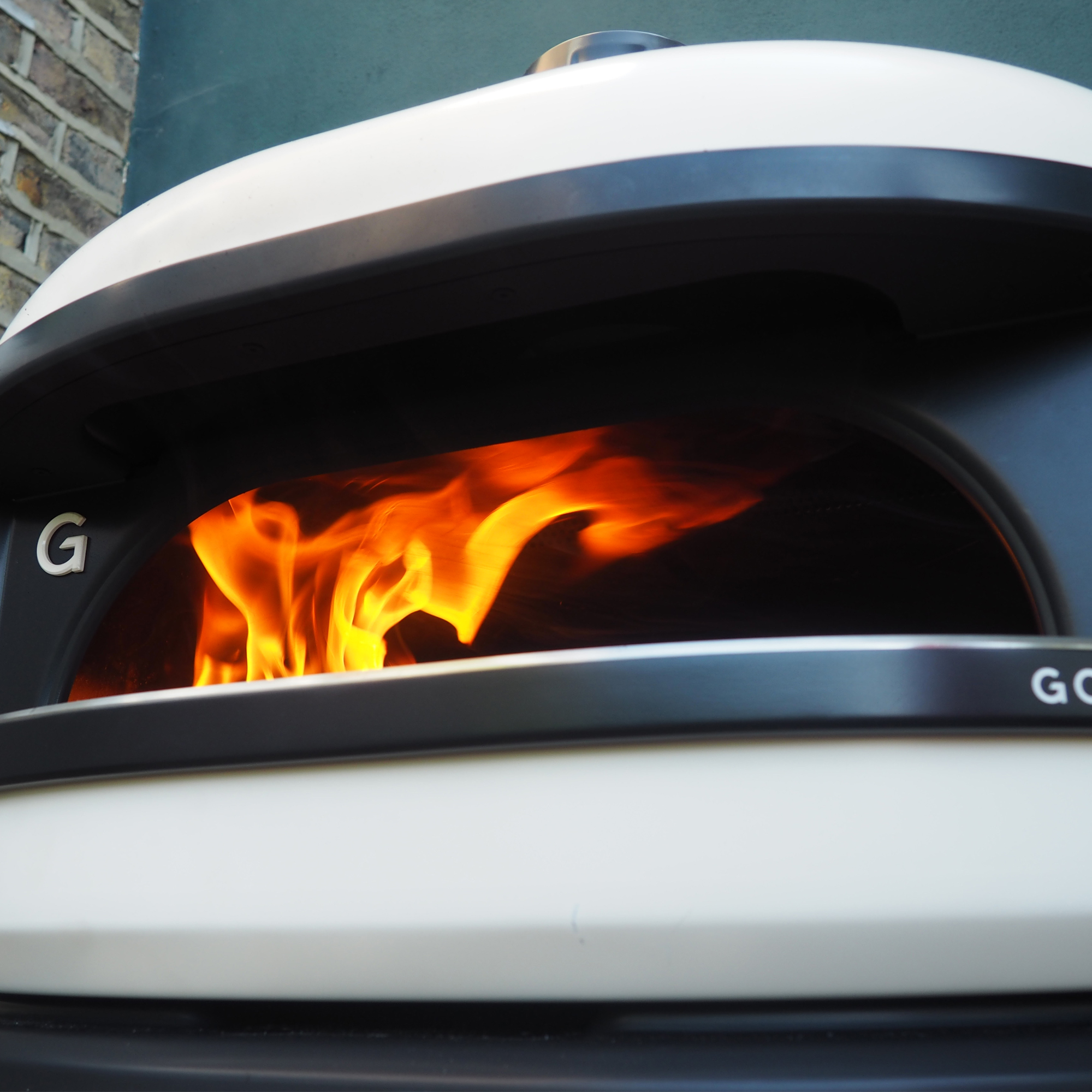 Gozney Dome pizza oven with rolling flame visible