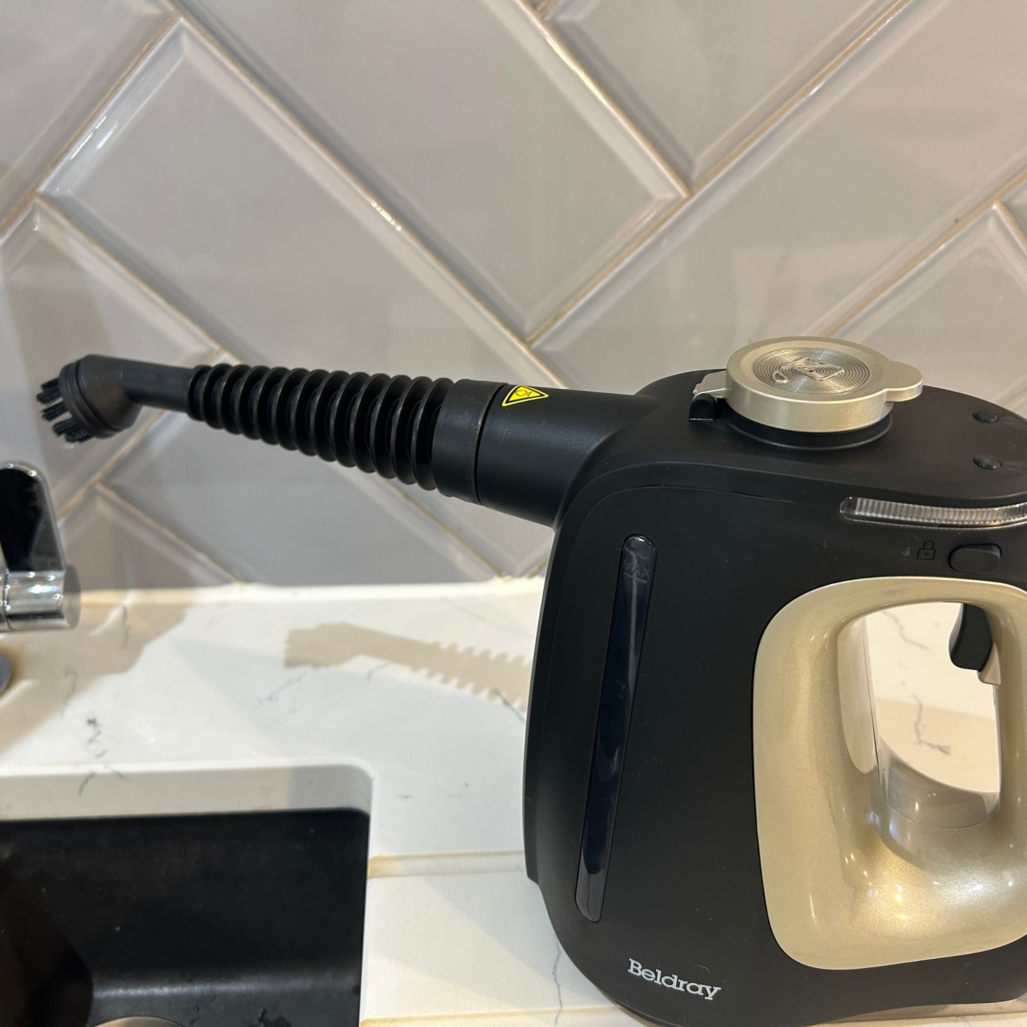 Beldray steam cleaner beside kitchen sink with round brush attachment